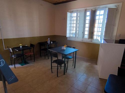 a dining room with tables and chairs and windows at Parvis Magna Hostal in Guaymallen