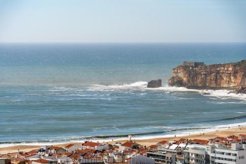 a view of a beach with buildings and the ocean at Horizonte Azul - New Renovated with Sea View in Nazaré