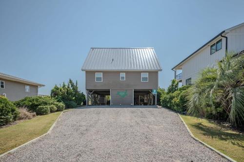 a driveway leading to a house with a garage at Linger Longer in Caswell Beach