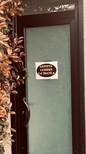 a sign on a door with a sign on it at Affittacamere Cà Bianca in Casa Rossa