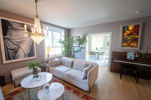 a living room with a couch and tables and a piano at Eksklusiv og sjarmerende leilighet på Frogner in Oslo