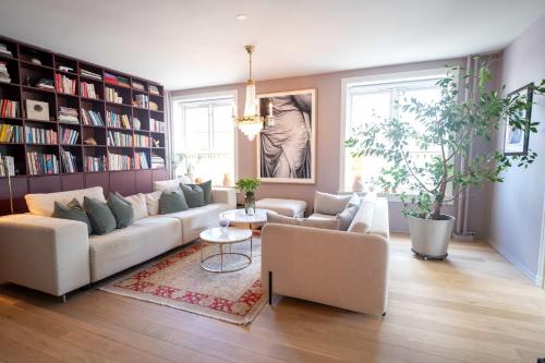 a living room with a couch and chairs and bookshelves at Eksklusiv og sjarmerende leilighet på Frogner in Oslo