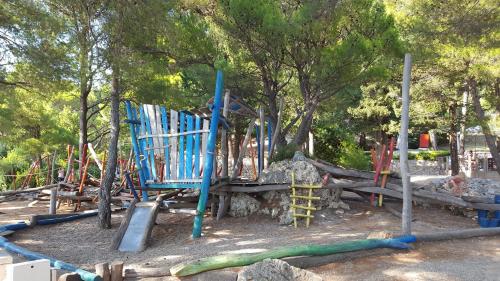 a playground with blue chairs in a park at Apartments Grbic in Mlini