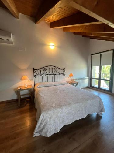 a bedroom with a large bed and two lamps on tables at HOTEL RURAL Casa Campo in Abay