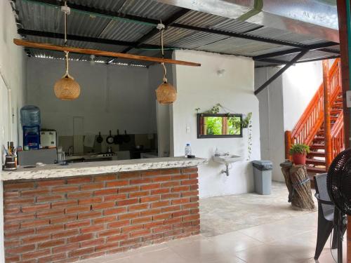 a brick bar in a kitchen with two hanging lights at Cabañas Spacetatacoa in Villavieja
