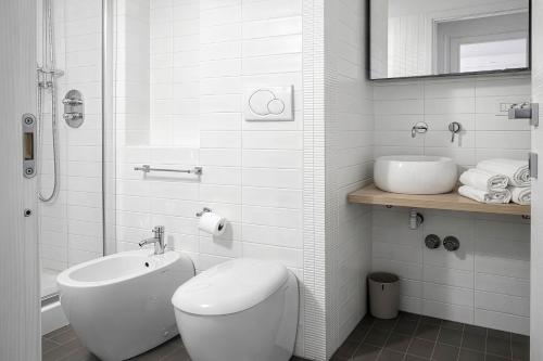 a white bathroom with a toilet and a sink at Maison Michela Sorrento in Sorrento