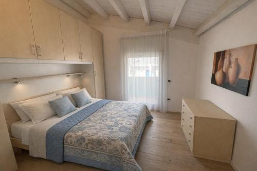 una camera da letto con un grande letto e una finestra di Residence Gianka - Agenzia Cocal a Caorle