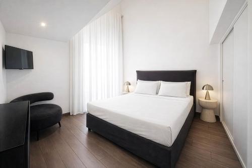 a bedroom with a large white bed and a chair at Maison Michela Sorrento in Sorrento