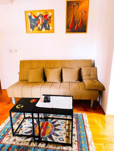 a living room with a couch and a coffee table at Hera Sweet Apartment in Niš