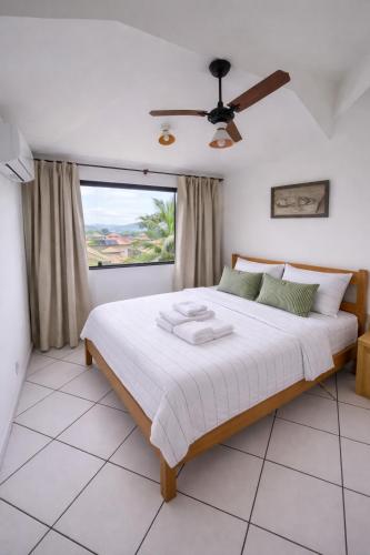 a bedroom with a large bed with a window at Morada dos Ventos Búzios in Búzios