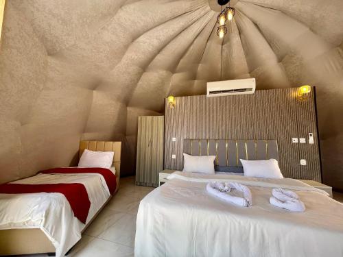 two beds in a room with a ceiling at Wadi rum trips in Wadi Rum