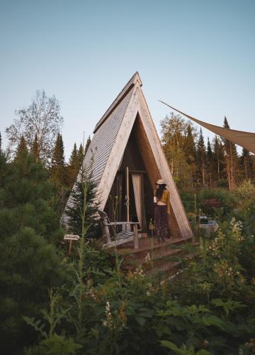 a person standing in the doorway of a small house at Farouche Tremblant Cabines nature avec bain nordique in Lac-Superieur