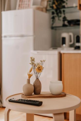 a table with a remote control and vases on it at Tonella Studio in Corfu