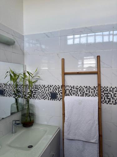 a white bathroom with a sink and a towel at Kaz KAFE in Mamoudzou