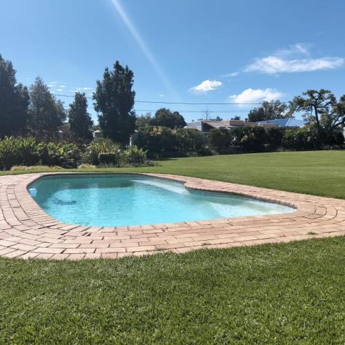 a small pool in the middle of a lawn at Lekkerrus guesthouse in Krugersdorp
