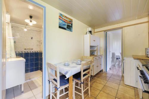 a kitchen with a table and chairs and a refrigerator at L'Océane in Apremont