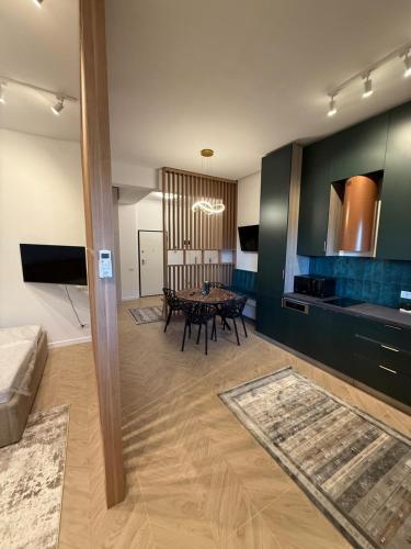 a living room with a table and a kitchen at Tomis Villa Center Studio in Constanţa
