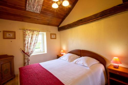 a bedroom with a large bed and a window at Domaine de pommarede in Carsac-Aillac
