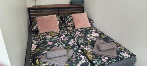 a bed with a blanket and pillows on it at Apartament u Piotrusia i Paulinki in Stronie Śląskie