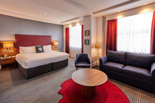 a hotel room with a bed and a couch at The Cumberland, London in London