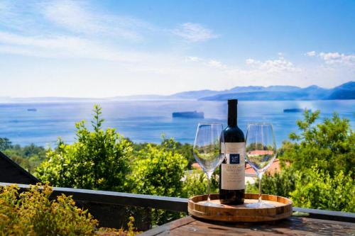 a bottle of wine sitting on a table with a glass at Apartments Alba Chiara in Kastav