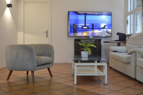 a living room with a tv and a couch and a table at Hotel Marín in Marín