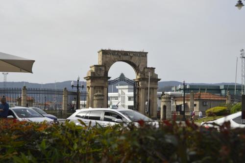 an arch in a parking lot with cars parked at Hotel Marín in Marín