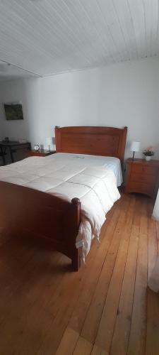 a large bed in a room with a wooden floor at Casa do Freire - Serra da Estrela in Aguincho