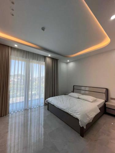 a bedroom with a bed and a large window at Villa Ban Mai in Tài Xá