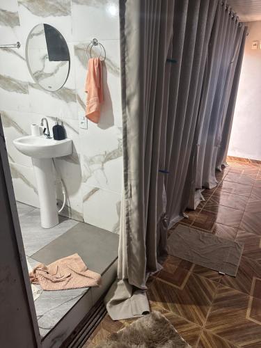 a bathroom with a shower with a sink and a mirror at Pousada Jangarelli in Guaíra