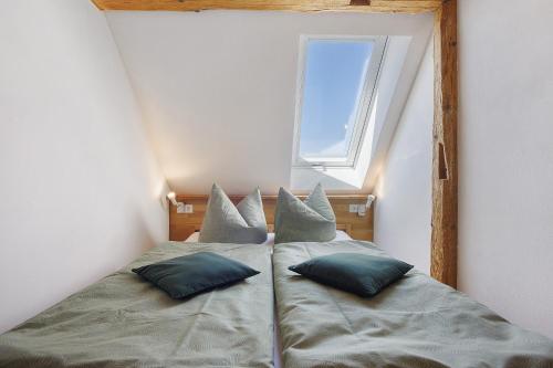 a bed with two pillows in a room with a window at Beim Senner in Halblech