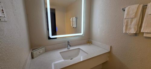 a bathroom with a sink and a mirror and towels at Super 8 by Wyndham Austin South I-35 in Austin