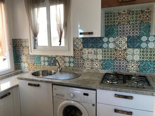 a kitchen with a sink and a washing machine at Waterside in Hammam Sousse