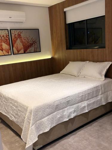 a bedroom with a large bed with a wooden wall at Apartamento Studio in Arujá