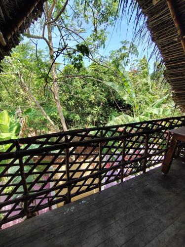 a wooden porch with a view of the trees at Search hurt stays in Kuilapayam