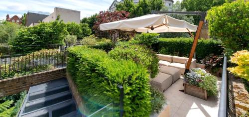 a garden with a swimming pool and an umbrella at Elegant Luxury Flat Regent s Park in London