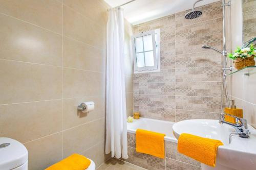 a bathroom with a tub and a sink and a toilet at Villa San Jose by Villa Plus in Cala en Porter