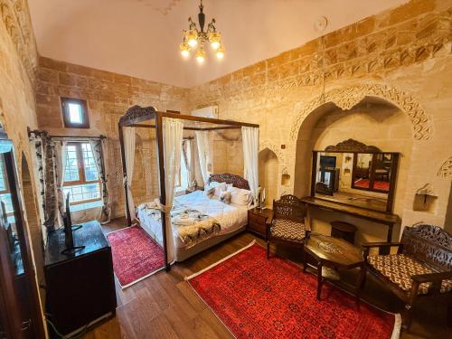 a bedroom with a bed with a mirror and a fireplace at Dara Konagı in Mardin