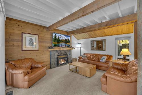 a living room with leather furniture and a fireplace at Pine Mountain - Unit 13 in Sunriver