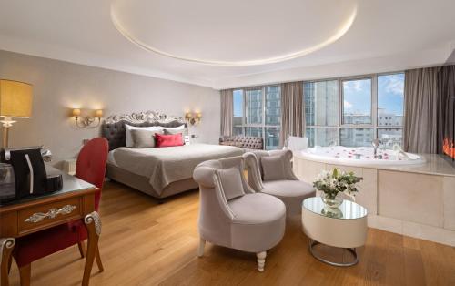 a hotel room with a bed and a bath tub at CVK Taksim Hotel Istanbul in Istanbul