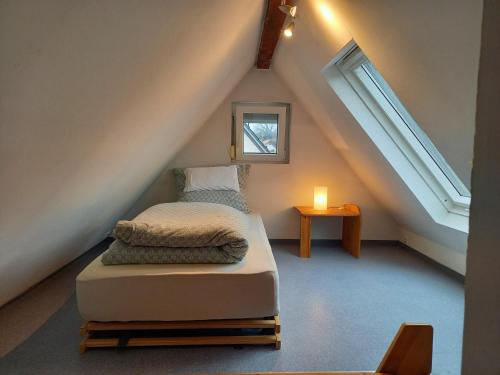 a bedroom with a bed in the attic with a candle at Freilandhof in Ötisheim