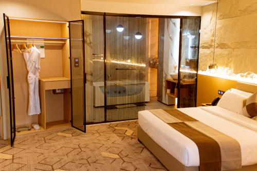 ein Hotelzimmer mit Bett und Dusche in der Unterkunft Bio Hôtel in Lomé