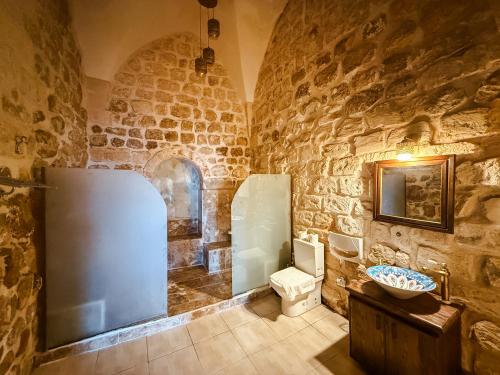 a stone bathroom with a toilet and a sink at Dara Konagı in Mardin