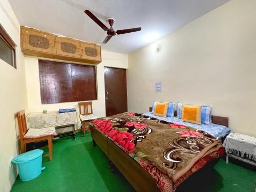 a bedroom with a large bed and a ceiling fan at Yatra Homestay in Joshīmath