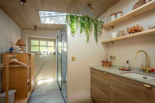 a kitchen with a sink and a shower in it at The Nook Guest House in Letchworth