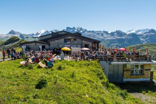 a crowd of people sitting outside of a building at Berghotel Bonistock in Frutt