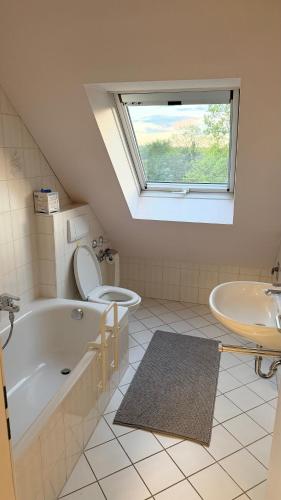 a bathroom with a tub and a toilet and a sink at Apartment Kist bei Würzburg in Kist