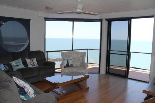 una sala de estar con un sofá y una mesa en Sunset Sails Penthouse Redcliffe, en Redcliffe