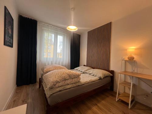 a small bedroom with a bed and a window at SKY Apartment 1 in Oświęcim