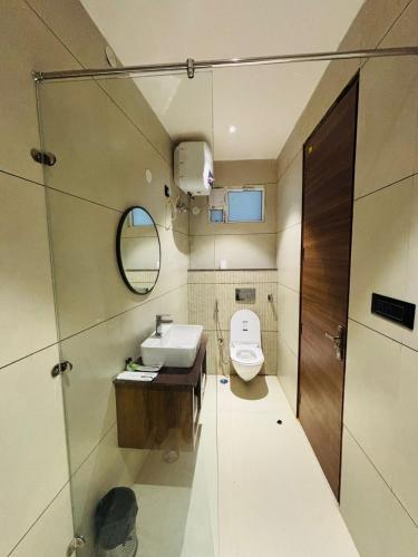 a bathroom with a toilet and a sink and a mirror at Hotel Hrishikesh High Tapovan in Rishīkesh